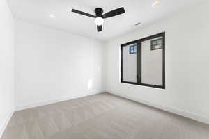 Empty room with light colored carpet and ceiling fan