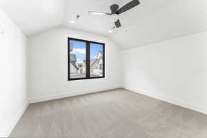 Bonus room with vaulted ceiling, light colored carpet, and ceiling fan