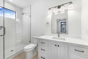 Bathroom with vanity, toilet, tile patterned floors, and walk in shower