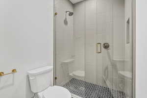 Bathroom with a shower with door and toilet