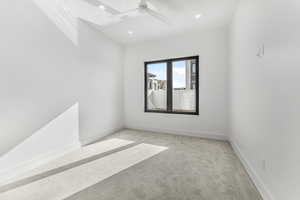 Unfurnished room with light colored carpet and ceiling fan