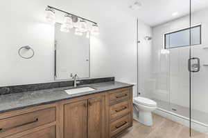 Bathroom with tile patterned flooring, vanity, an enclosed shower, and toilet