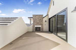 View of patio / terrace featuring an outdoor stone fireplace