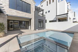 View of swimming pool with an in ground hot tub and a patio