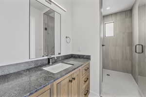 Bathroom with vanity and a shower with shower door