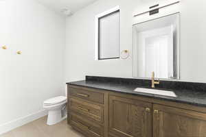 Bathroom with tile patterned flooring, vanity, and toilet