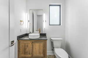 Bathroom featuring parquet flooring, vanity, and toilet