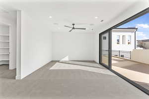 Carpeted empty room with a textured ceiling and ceiling fan