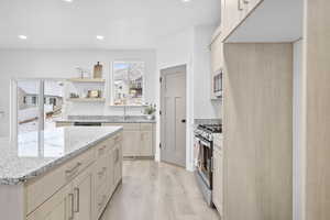 Kitchen featuring sink, light hardwood / wood-style flooring, appliances with stainless steel finishes, light stone counters, and light brown cabinets