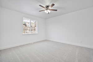 Unfurnished room with ceiling fan and carpet flooring