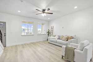 Living room featuring ceiling fan and light hardwood / wood-style floors