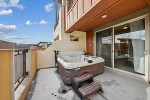 View of patio / terrace featuring a hot tub and a balcony