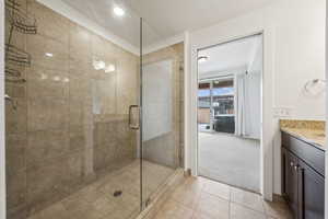 Bathroom featuring tile patterned floors, vanity, and a shower with door