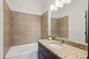 Bathroom with vanity and tiled shower / bath