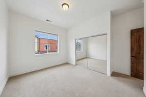 Unfurnished bedroom with a closet and light carpet