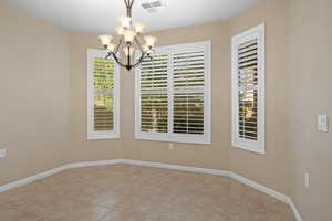 Unfurnished room with a chandelier