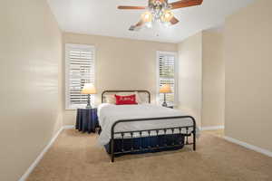 Bedroom with ceiling fan and light colored carpet