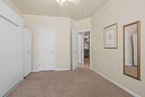 Unfurnished bedroom featuring ceiling fan and light colored carpet