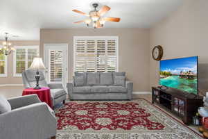 Living room with ceiling fan with notable chandelier