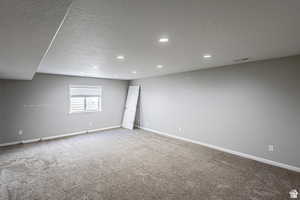 Unfurnished room with carpet flooring and a textured ceiling