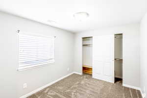 Unfurnished bedroom featuring a closet and carpet flooring