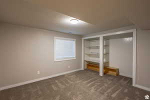 Unfurnished bedroom with dark carpet and a textured ceiling