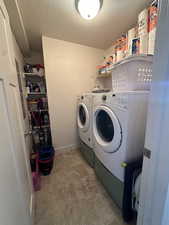 Laundry room with washing machine and clothes dryer and a textured ceiling