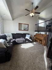 Main Living room featuring carpet floors, ceiling fan, vaulted ceiling, and a textured ceiling
