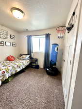 Carpeted bedroom featuring a textured ceiling
