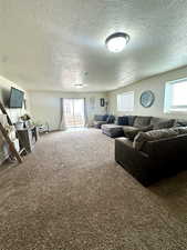 Living room with a textured ceiling and carpet flooring