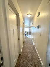 Hallway featuring carpet and a textured ceiling