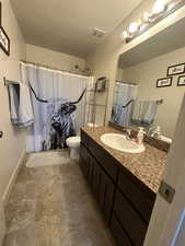 Bathroom with vanity, a shower with shower curtain, a textured ceiling, and toilet