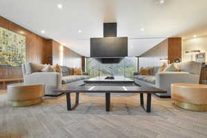 Carpeted living room with wooden walls