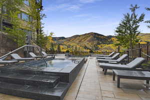 View of pool featuring an in ground hot tub, a mountain view, and a patio area