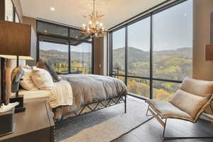 Bedroom featuring expansive windows, access to exterior, and a mountain view