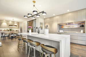 Kitchen with a barn door, decorative light fixtures, and a large island with sink