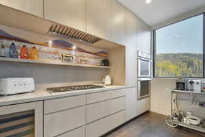 Kitchen featuring stainless steel appliances, dark wood-type flooring, and wine cooler