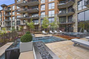 View of pool with a hot tub and a patio