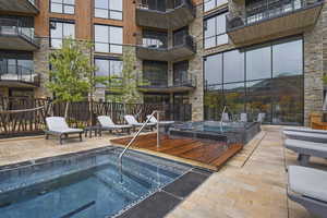 View of swimming pool with a patio and a community hot tub