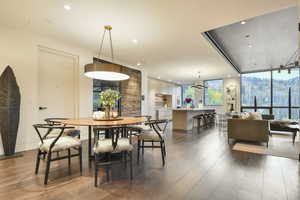 Dining space with hardwood / wood-style floors and a wall of windows