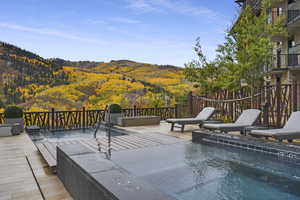 Wooden terrace featuring a mountain view and a swimming pool