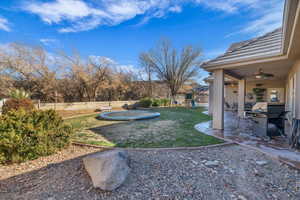 View of yard featuring a playground, a patio, a trampoline, and ceiling fan