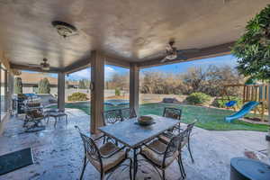 View of patio with a grill, a fenced in pool, a playground, and ceiling fan