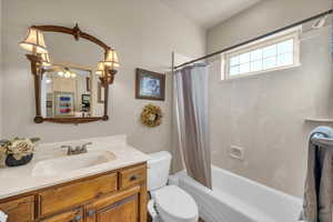 Full bathroom with vanity, shower / tub combo, and toilet