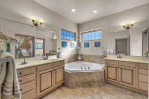 Bathroom featuring a relaxing tiled tub and vanity