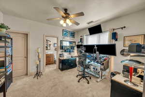 Office area with ceiling fan and light carpet