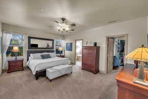 Carpeted bedroom with connected bathroom, a spacious closet, a closet, and ceiling fan