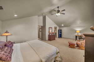 Carpeted bedroom with ceiling fan and high vaulted ceiling