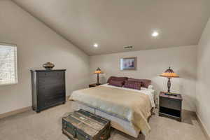 Bedroom with vaulted ceiling and light colored carpet