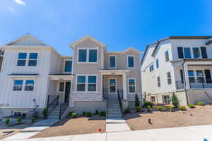Townhome / multi-family property featuring board and batten siding and stone siding